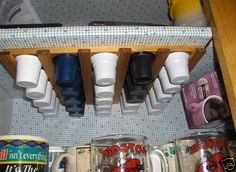 several cups are lined up on a shelf