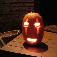 a carved pumpkin with two glowing eyes on it's head, sitting in front of a brick wall