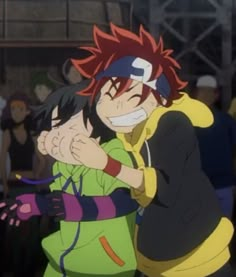 two anime characters hugging each other in front of a group of people with their arms around one another