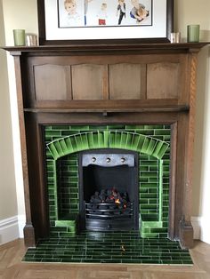 a fireplace with a green tile hearth and wood mantle