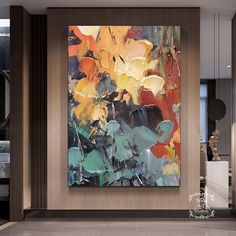 an abstract painting hangs in the corner of a room