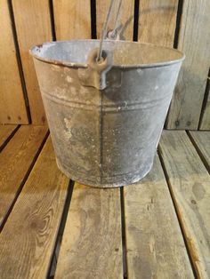 an old bucket sitting on top of a wooden floor