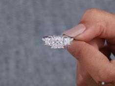 a person holding a diamond ring in their hand