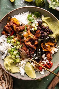 a bowl filled with rice, beans, and other food on top of a table