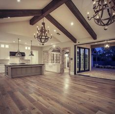 a large open floor plan with wood floors and chandelier hanging from the ceiling