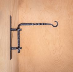 an iron hook on the side of a wooden door