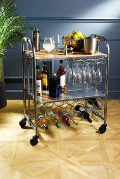 a bar cart with wine glasses and bottles on it