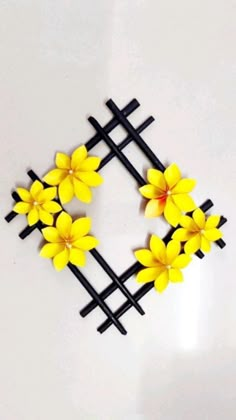 yellow flowers are placed on black sticks in the shape of a square frame with four crosses