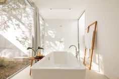 a large white bath tub sitting next to a walk in shower room with glass walls