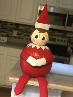 an elf doll sitting on top of a kitchen counter