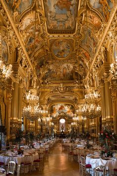 an ornately decorated dining room with chandeliers and tables set up for dinner