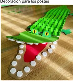 an alligator made out of legos sitting on top of a wooden floor