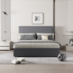 a modern bedroom with white walls and grey furniture