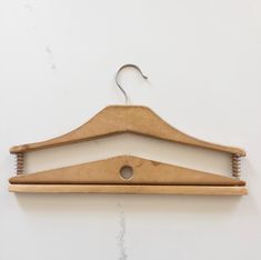 a pair of wooden clothes hangers on a white wall