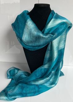 This hand painted silk scarf is made from luxurious silk jacquard. With alternating panels of silk organza and woven jacquard, this large oblong scarf has a striking sheen and is suitable for evening or day wear. Painted by Acacia Silks Tasmania, this unique scarf is impossible to replicate. The dyes used to paint this scarf have been fixed and the easy-care instructions are supplied with the item. Silk Shawl For Wedding, Artistic Silk Scarves For Weddings, Artistic Silk Scarves For Wedding, Silk Shawl Scarf, Silk Shawl For Evening, Elegant Silk Shawl Dupatta, Elegant Silk Dupatta Shawl, Artistic Silk Wedding Scarves, Elegant Blue Silk Dupatta