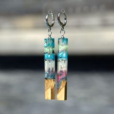 the earrings are made from wood and have colorful glass beads hanging from it's earwires