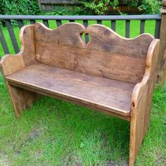 an old wooden bench sitting in the grass