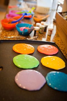 there are many different colored cookies on the pan