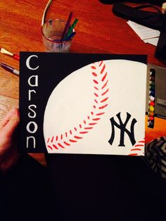 a person holding up a book with a baseball on it and the words carosson written in black