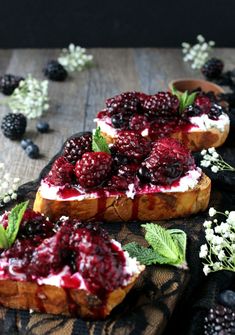 two pieces of bread with berries and whipped cream on them, sitting on a table