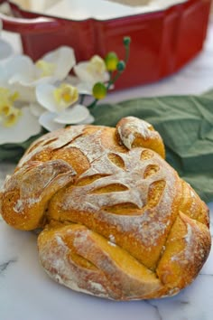 two loaves of bread sitting on top of a marble counter next to white flowers