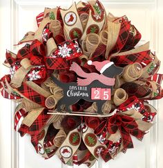 a christmas wreath made out of burlocks and ribbon with a reindeer on it