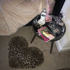 a heart shaped animal print rug sitting on top of a table next to a bed