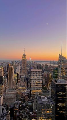 the city skyline is lit up at night, with skyscrapers in the foreground