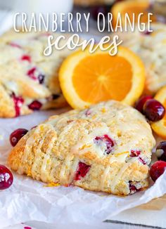 cranberry orange scones on parchment paper next to sliced oranges