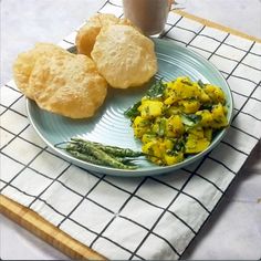 a plate with some food on it next to a cup of coffee and a napkin