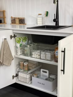 an organized kitchen with white cabinets and drawers