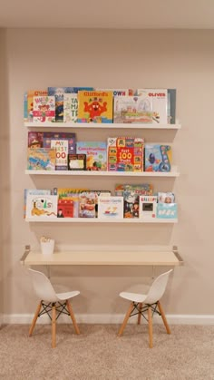 two white chairs sitting in front of a book shelf filled with books on top of it