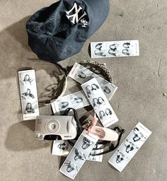 a hat, camera and other items are on the ground next to some tags that say new york yankees