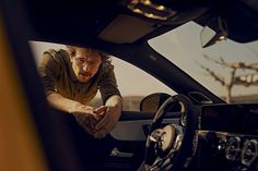 a man sitting in the driver's seat of a car