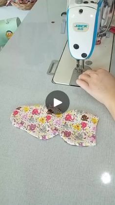 someone is using an electric sewing machine to sew flowers on the fabric with scissors