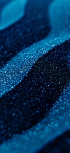 rain drops on the surface of a blue and black tablecloth with white lines in the background