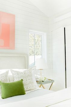 a bedroom with white walls and green pillows