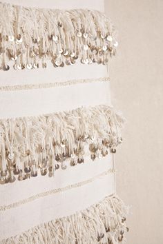 a wall hanging with beads and fringes on it