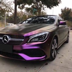 a car with purple paint on it parked in the street