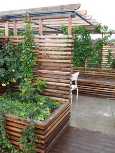 a wooden planter filled with lots of green plants