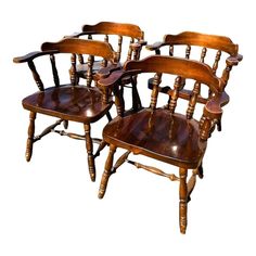 four wooden chairs sitting next to each other