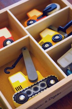 the toy cars are in the wooden box on the table and ready to be played