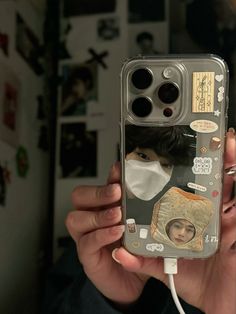 a person holding up a cell phone with an image of someone wearing a face mask