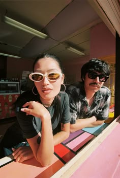 two people sitting at a table with sunglasses on