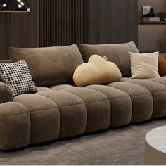 a living room filled with lots of brown couches next to a white coffee table