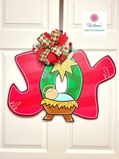 a door hanger with a christmas wreath on it's side and a bow hanging from the top