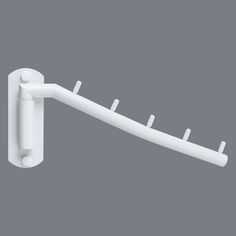 a white wall mounted toothbrush holder on a gray background with clippings for teeth