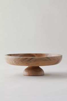 a wooden bowl sitting on top of a white table