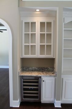 an empty kitchen with white cabinets and granite counter tops