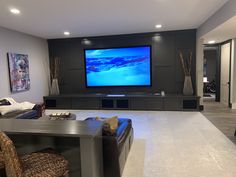 a living room filled with furniture and a flat screen tv mounted to the side of a wall